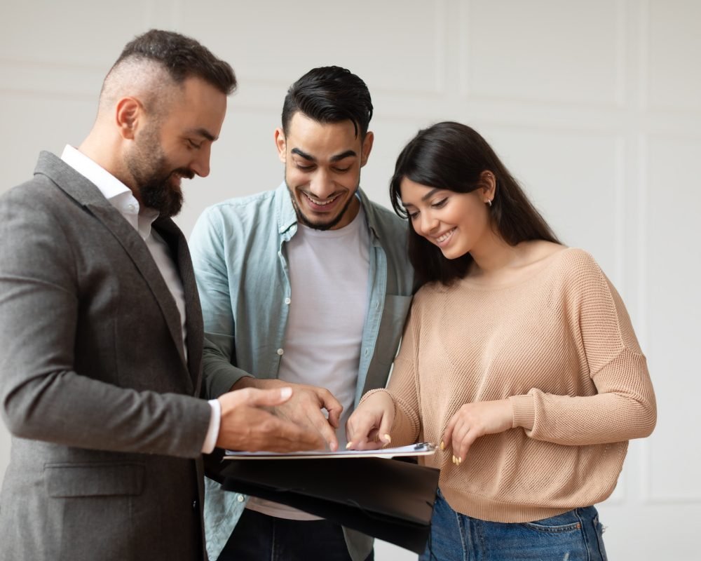 couple-buying-new-apartment-house-agent-showing-documents-blueprints.jpg